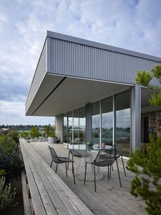 an outdoor dining table and chairs on a wooden deck