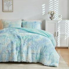 a bed with blue and white comforters in a room