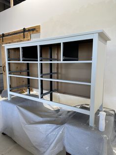 an unfinished entertainment center is being painted white