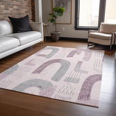 a living room filled with furniture and a large rug on top of a hard wood floor