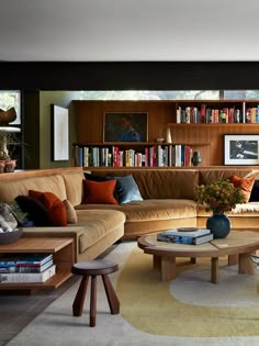 a living room filled with lots of furniture and bookshelves full of books on shelves