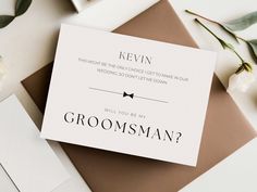 a wedding card with the words groomsman on it next to flowers and envelopes