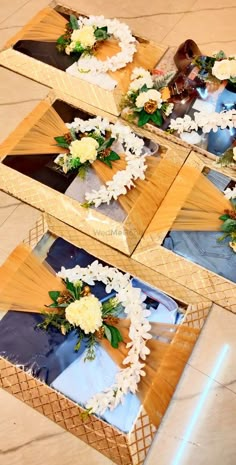 three mirrors with flowers on them sitting on the floor