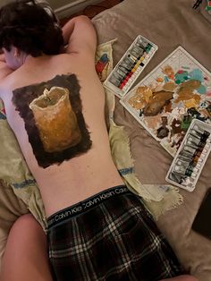 a person laying on top of a bed covered in tattoos