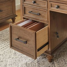 a wooden desk with drawers on top of it and a rug in front of it