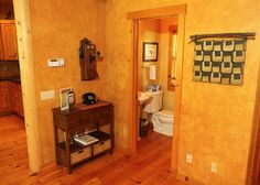 a bathroom with wood floors and yellow walls