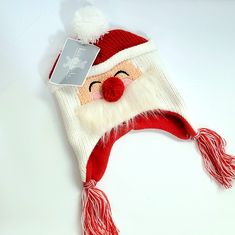 a knitted santa claus hat with a tag attached to the front and side of it