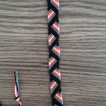 a close up of a black and red rope with two different colored beads on it