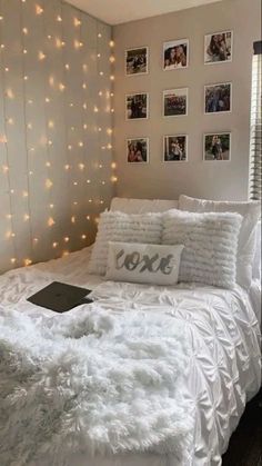 a white bed topped with pillows and blankets next to pictures on the wall above it