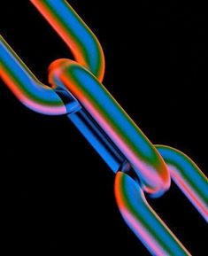 a close up view of a chain that is colored in different colors and shapes on a black background