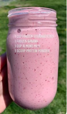 a hand holding a pink smoothie in a mason jar with instructions on how to make it