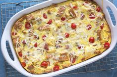 a casserole dish with meat, cheese and tomatoes in it on a cooling rack