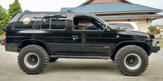 a black suv parked in front of a house