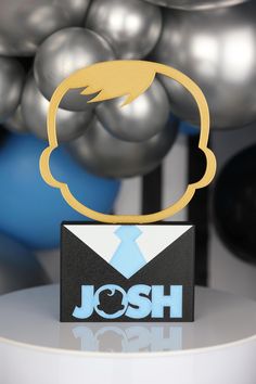 a table with balloons and a sign that says josh on the top in front of it