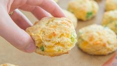 a hand holding up a biscuit that has been made with cheese and broccoli