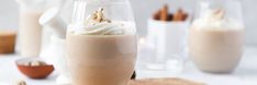 there is a drink with whipped cream and cinnamon sticks in the glass on the table