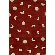 a red rug with white polka dots and crescents on the top, in front of an orange background