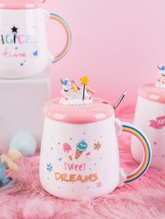 two mugs with unicorn decorations on them sitting next to each other