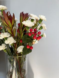 a vase filled with white and red flowers