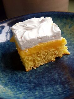 a piece of cake sitting on top of a blue plate with white frosted topping