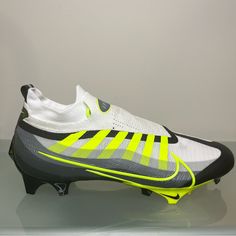 a pair of white and yellow soccer cleats sitting on top of a table