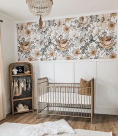 a baby's room with floral wallpaper and a crib in the corner