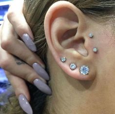 a close up of a person with some piercings on their ears and behind the ear