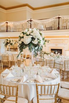 the tables are set with white flowers and place settings