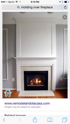 a fire place in the middle of a room with white walls and wood flooring