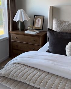 a bedroom with a bed, nightstand and window