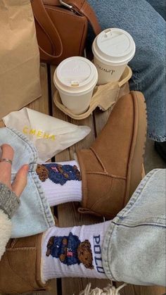 someone's feet with bear socks and coffee cups