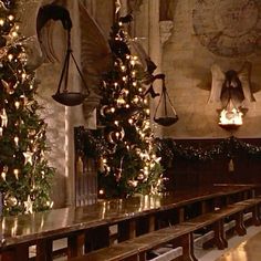 christmas trees are lined up in the middle of a long table with lights on them