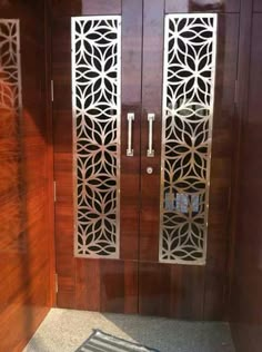 a wooden door with intricate carvings on the sides and glass panels at the front entrance