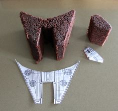 two pieces of chocolate cake next to a cut out star wars tie