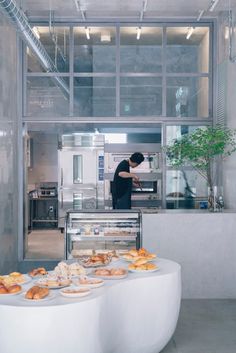 a man standing in front of a counter filled with pastries