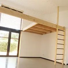 an empty room with a ladder hanging from the ceiling