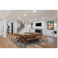 a living room filled with furniture and a fire place in the middle of a wooden floor