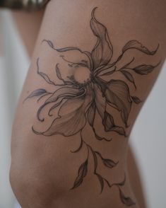 a woman's thigh with a flower tattoo on it