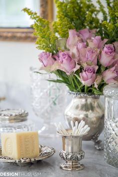 a table topped with vases filled with purple flowers and other decorative items on top of it