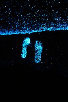 a pair of flip flops are lit up in the dark with blue lights on them