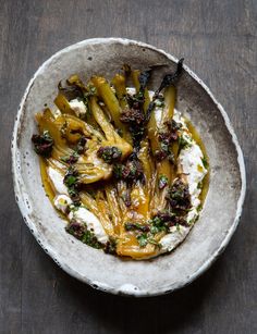 a white bowl filled with food on top of a wooden table