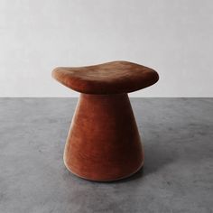 a brown stool sitting on top of a cement floor