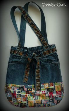 a purse made out of old jeans with patches on the front and straps, hanging from a wall