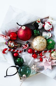 an assortment of christmas ornaments are displayed in a box