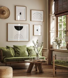 a living room with green couches and pictures on the wall above them, along with wicker furniture