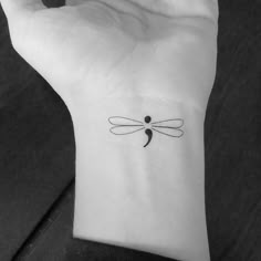 a small dragonfly tattoo on the wrist