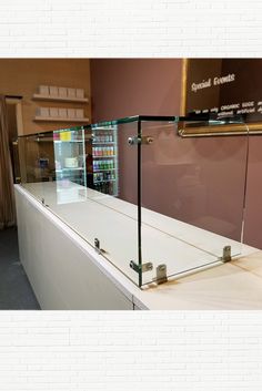 an empty counter in a store with shelves and signs on the wall next to it