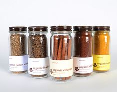 five jars filled with different types of spices