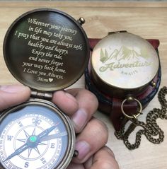 a person holding a compass and some other items