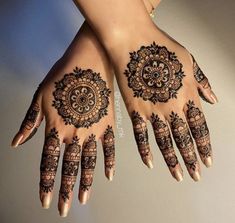 two hands with henna tattoos on them